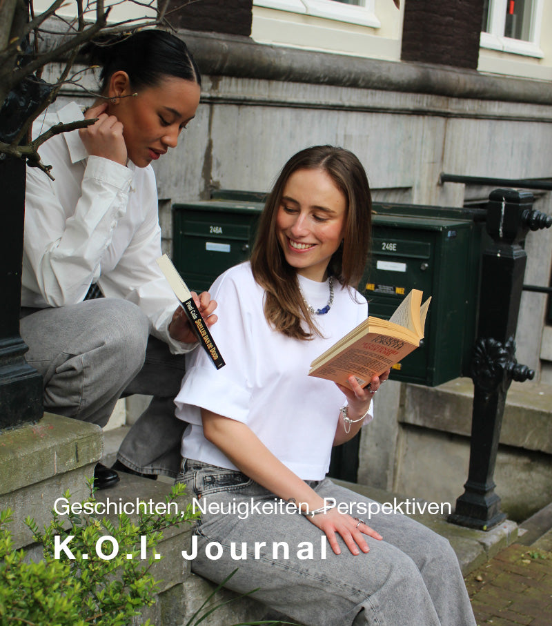 Two people sitting on steps, reading books with 'K.O.I. Journal' text overlay.